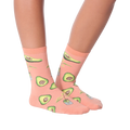 Lifestyle shot of woman's legs wearing peach avocado socks, different pose.