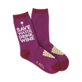 A pair of women's crew socks in deep purple.  They feature a 'Save Water Drink Wine' graphic and a small bunch of yellow-green grapes.