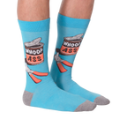 Flat lay photo of a pair of 'Whoop Ass' socks on a black background.