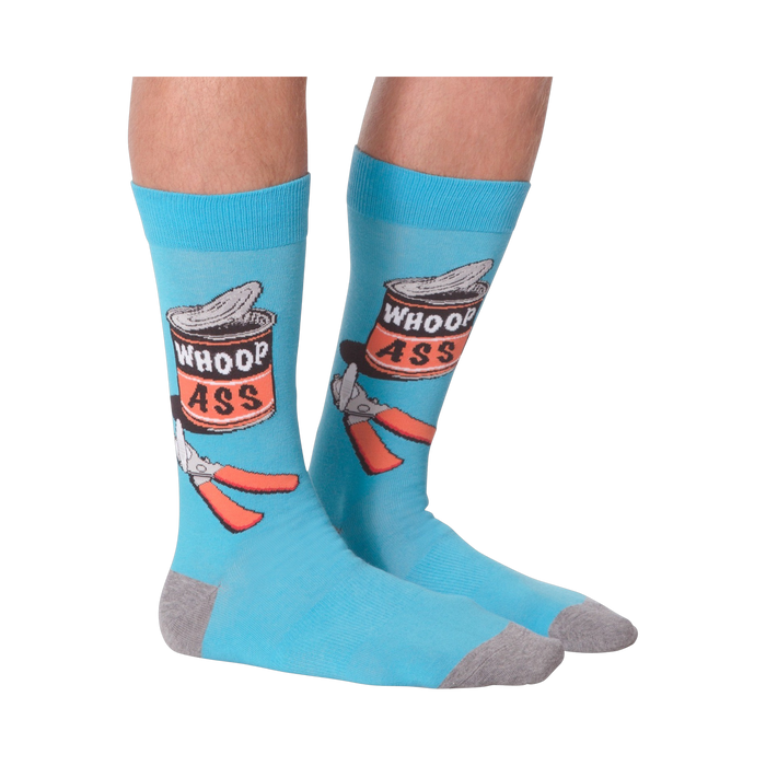 Flat lay photo of a pair of 'Whoop Ass' socks on a black background.