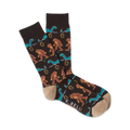 A pair of brown crew socks with a pattern of Bigfoot and the Loch Ness Monster in teal and brown.  The socks have a tan toe and heel.