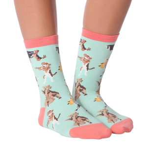 A pair of mint green socks with a pattern of cartoon dogs playing musical instruments. The socks have pink toes and heels.