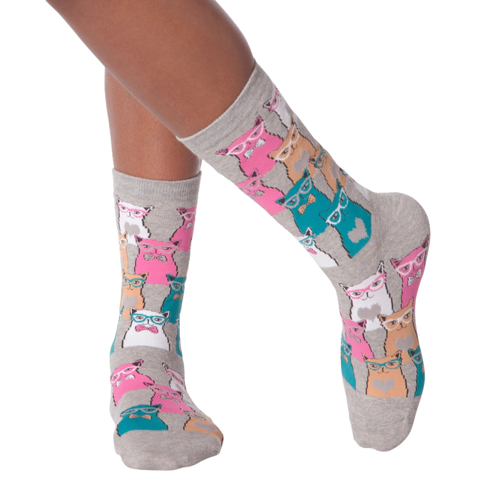 Close-up of a person's legs wearing grey Smarty Cats socks.