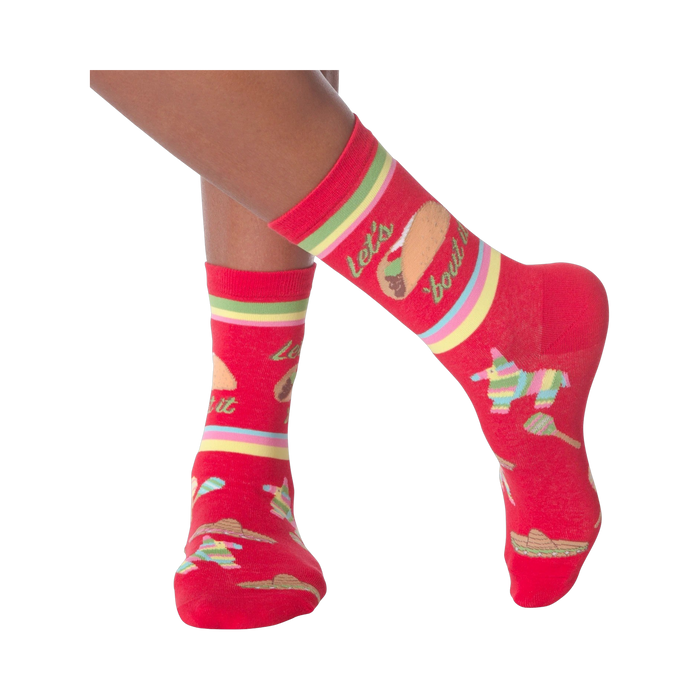 Lifestyle shot: Woman's legs wearing the 'Let's Taco Bout It' socks while casually holding a taco.