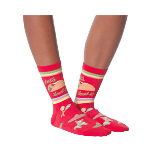 Pair of 'Let's Taco Bout It' socks on a black background, showcasing the full design.