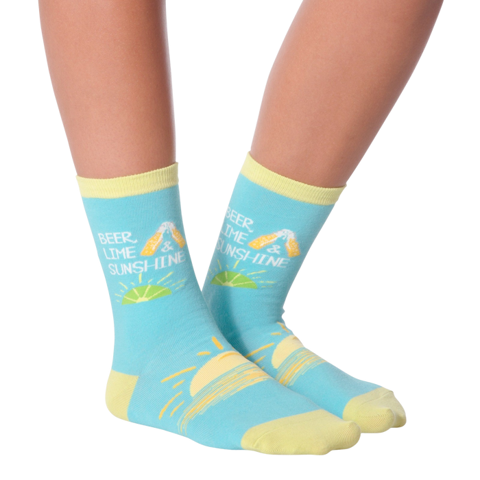 A person is sitting with their feet on a table. They are wearing blue socks with a pattern of lemons and the text 