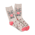 A pair of beige crew socks with a pink coffee cup design and shooting stars. The text 'But First, Coffee' is prominently displayed.