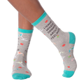 Lifestyle shot of woman's legs wearing the 'I Have Mixed Drinks About Feelings' socks, showing the fit and style on the feet.
