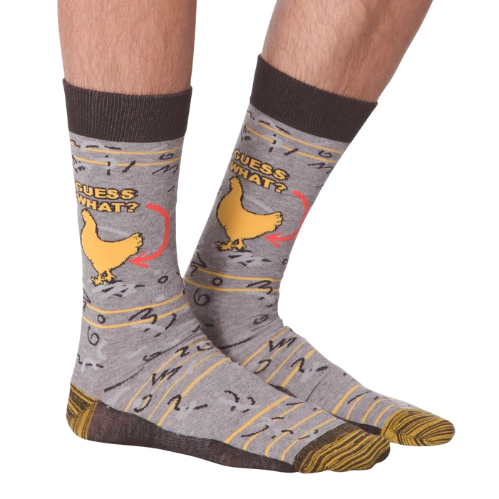 A pair of gray socks with a brown cuff. The socks have a pattern of chickens on them. The chicken has an arrow pointing to it with the words 