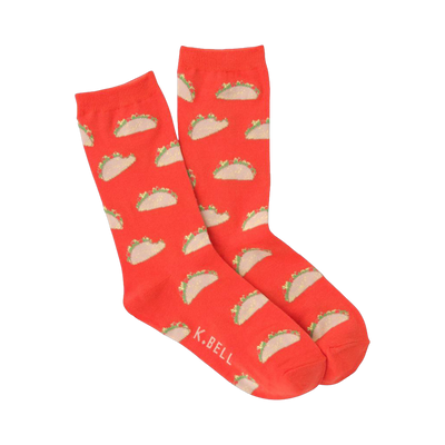 A pair of orange crew socks featuring a repeating pattern of small, illustrated tacos. The tacos are light brown with green and tan details.