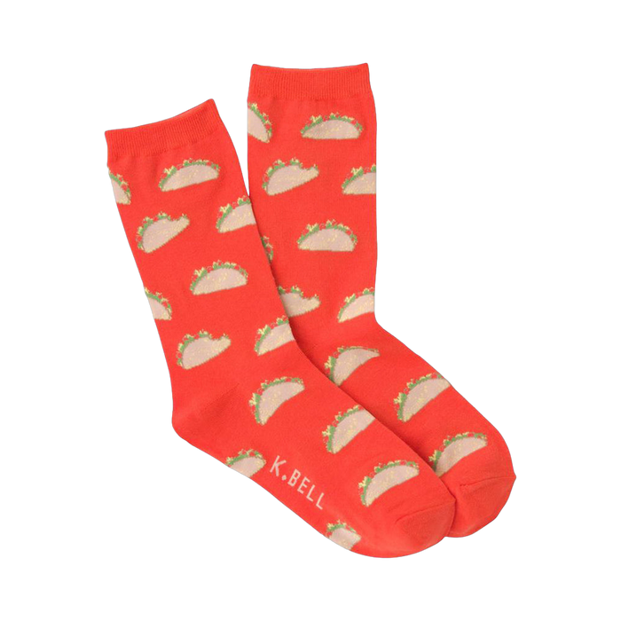 A pair of orange crew socks featuring a repeating pattern of small, illustrated tacos. The tacos are light brown with green and tan details. }}