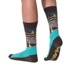 Pair of crew socks worn on legs, showing a dark grey upper with Loch Ness Monster, UFO, and teal feet.