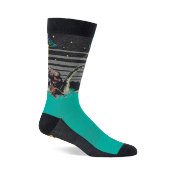 Single crew sock with dark grey top and teal foot, depicting Bigfoot, Loch Ness Monster, and a UFO at night.