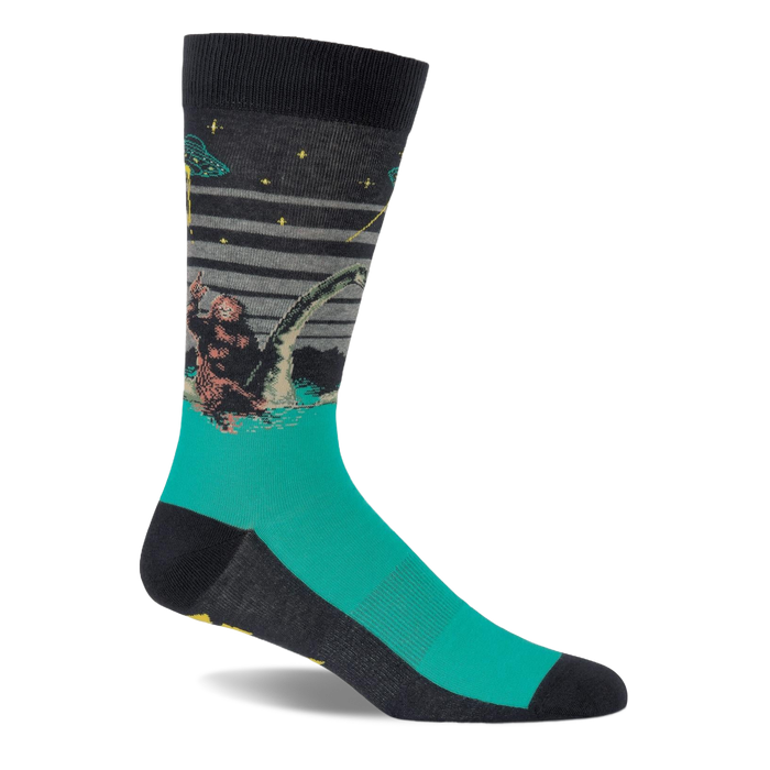 Single crew sock with dark grey top and teal foot, depicting Bigfoot, Loch Ness Monster, and a UFO at night.