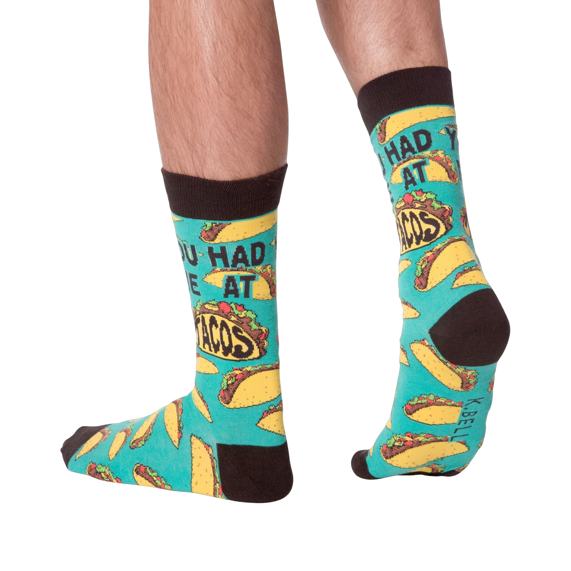 Lifestyle photo showing the 'You Had Me at Tacos' socks on a person's feet. The teal and yellow sock pattern is visible.