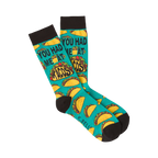 Pair of teal crew socks with a repeating pattern of tacos and the phrase 'You Had Me at Tacos.'  Black cuff.