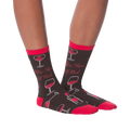 Another lifestyle shot showcasing the 'Fifty Sips of Red' socks on a model's legs from a slightly different angle.
