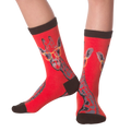 Lifestyle shot showing the socks on a person's legs.  The socks are red with a giraffe pattern.