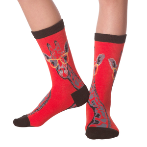 Lifestyle shot showing the socks on a person's legs.  The socks are red with a giraffe pattern.