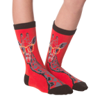 Another lifestyle shot of the red socks with the giraffe pattern on a person's feet.