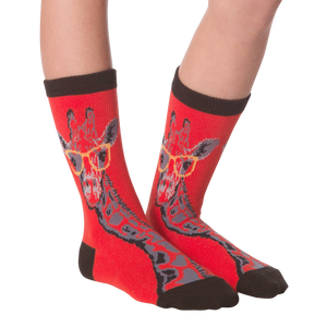 Another lifestyle shot of the red socks with the giraffe pattern on a person's feet.