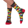 Lifestyle shot of person's legs wearing the 3D Jigsaw socks. The socks are black with colorful puzzle pieces.