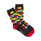 Pair of crew socks on a white background.  The socks are black with a colorful jigsaw puzzle design and red cuffs.