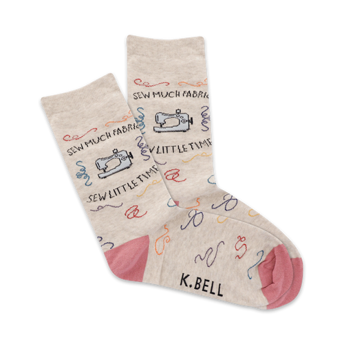 Beige crew socks with colorful sewing machine and thread designs. Pink heel and toe. 'Sew Much Fabric!' written on the socks.