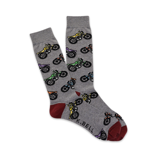 Pair of grey crew socks with a repeating pattern of multicolored motorcycles.  Red and grey heel and toe.