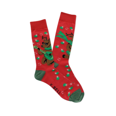 Pair of red crew socks with green cuffs, heels, and toes, featuring brown reindeer in sunglasses playing green guitars with starbursts and green ovals.