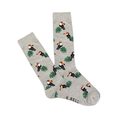 A pair of light gray crew socks with a repeating pattern of pixelated toucans and green leaves.  The socks are folded slightly.