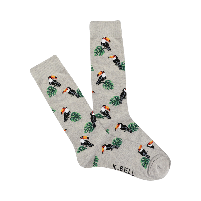 A pair of light gray crew socks with a repeating pattern of pixelated toucans and green leaves.  The socks are folded slightly. }}