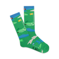 Pair of crew socks showcasing a playful golf course design. Predominantly green with blue water features and yellow flags.  'K.BELL' is subtly printed on the sole.