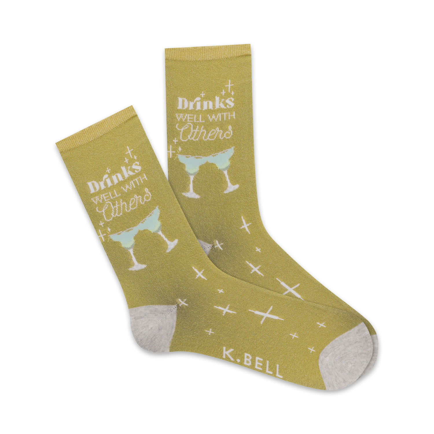 Pair of crew socks in mustard yellow. Design features white text 'Drinks Well With Others' and light green margarita glasses. Small white crosses are scattered on the socks.