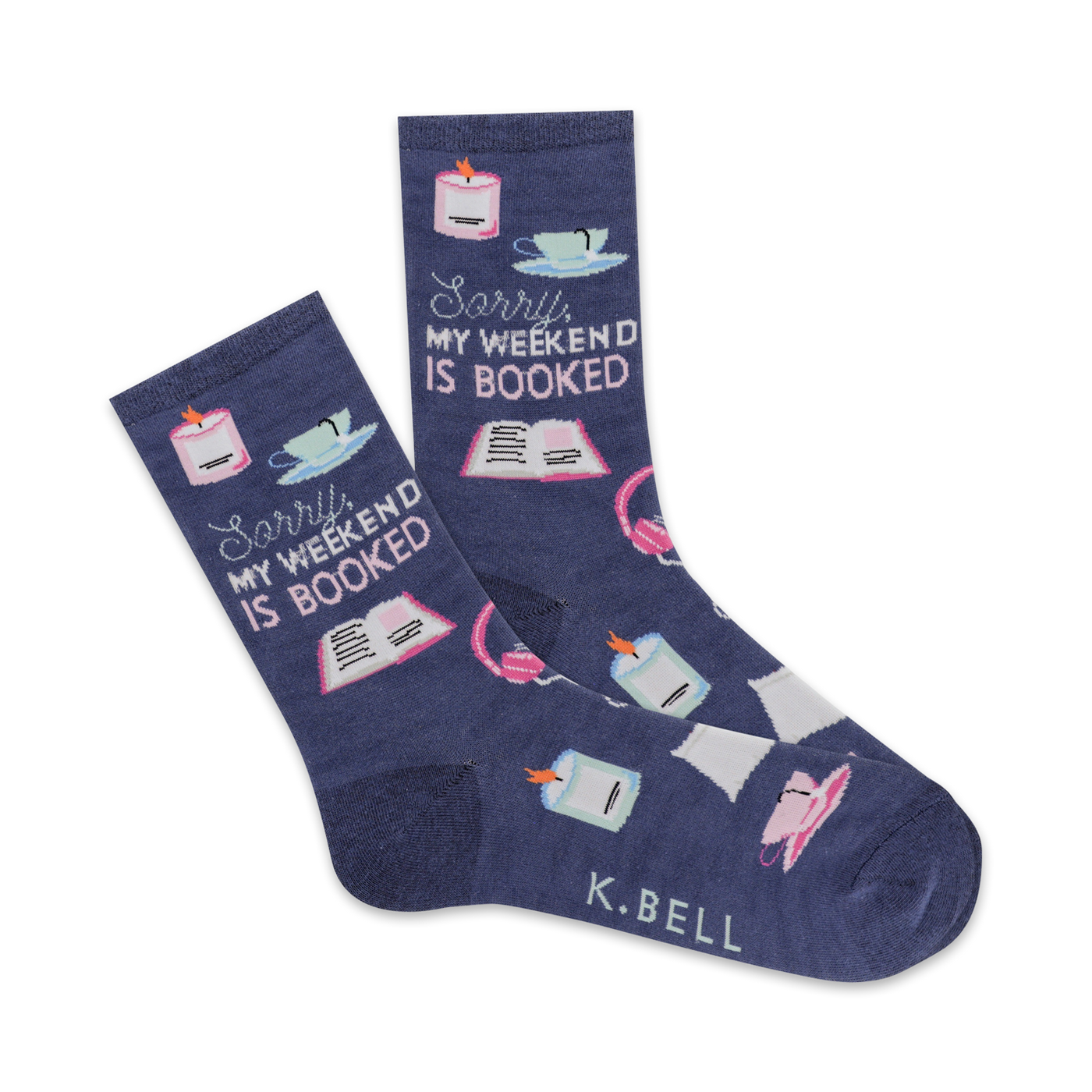 A pair of navy blue crew socks with illustrations of books, candles, teacups, and headphones. The text 'Sorry, my weekend is booked' is prominently displayed.