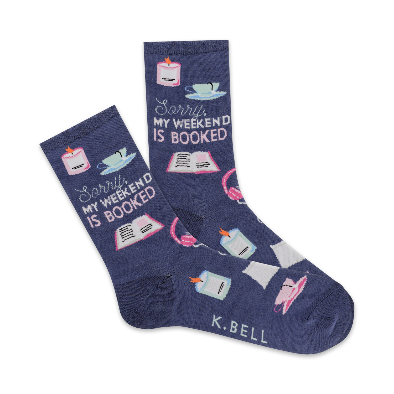 A pair of navy blue crew socks with illustrations of books, candles, teacups, and headphones. The text 'Sorry, my weekend is booked' is prominently displayed.