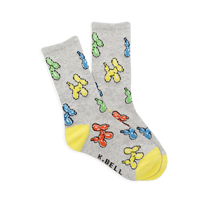 Pair of gray crew socks with colorful balloon dog pattern in yellow, blue, green, red. Bright yellow heel and toe sections visible.