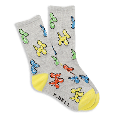 Pair of gray crew socks with colorful balloon dog pattern in yellow, blue, green, red. Bright yellow heel and toe sections visible.