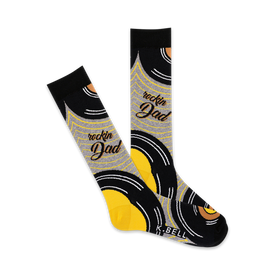 crew-length men's socks with black background and yellow and gray record album graphics, and 'rockin' dad' in vertical yellow and gray letters.   