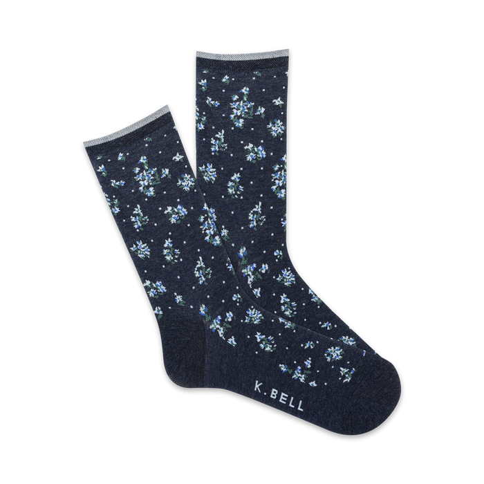 crew length women's socks feature dark blue background with small five-petal flowers in baby blue and white.   