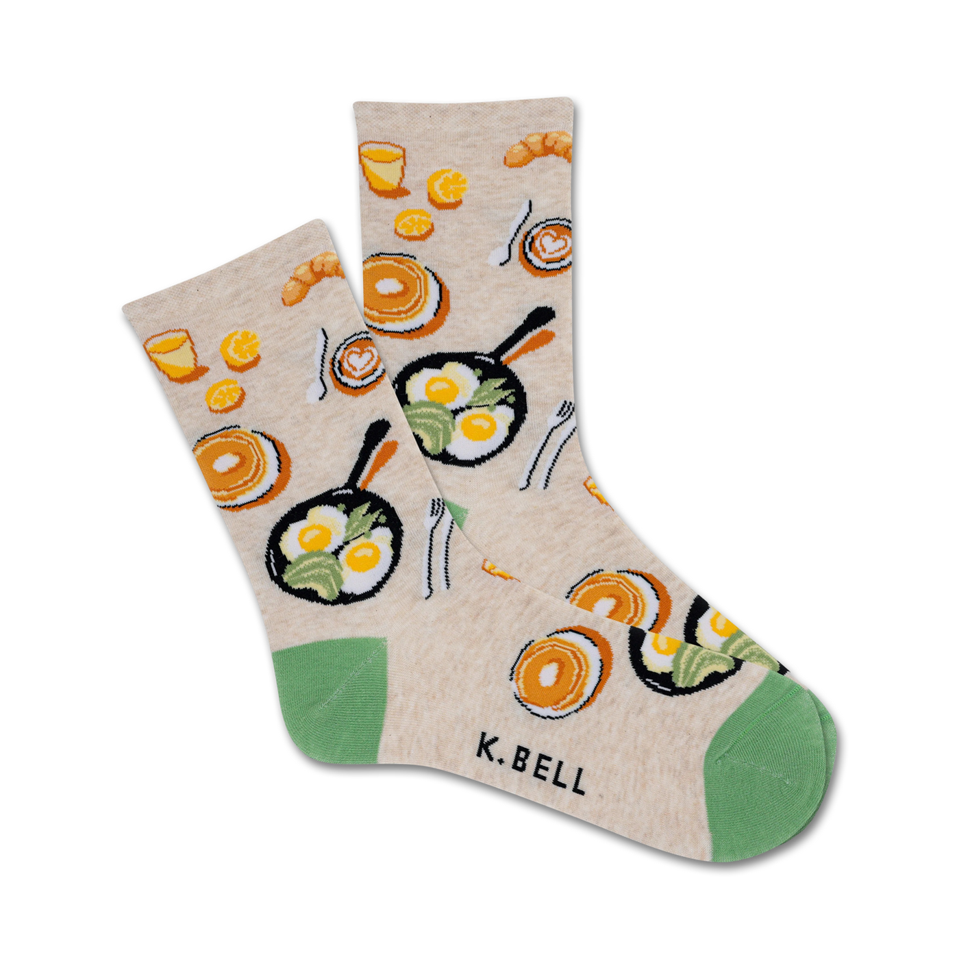 Cream-colored crew socks with illustrations of fried eggs, pancakes, coffee cups, and croissants. Green accents at the heel and toe.