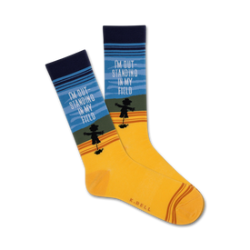   yellow crew socks with blue cuffs, brown toes, and a black scarecrow pattern. text on socks reads 'i'm outstanding in my field'.   