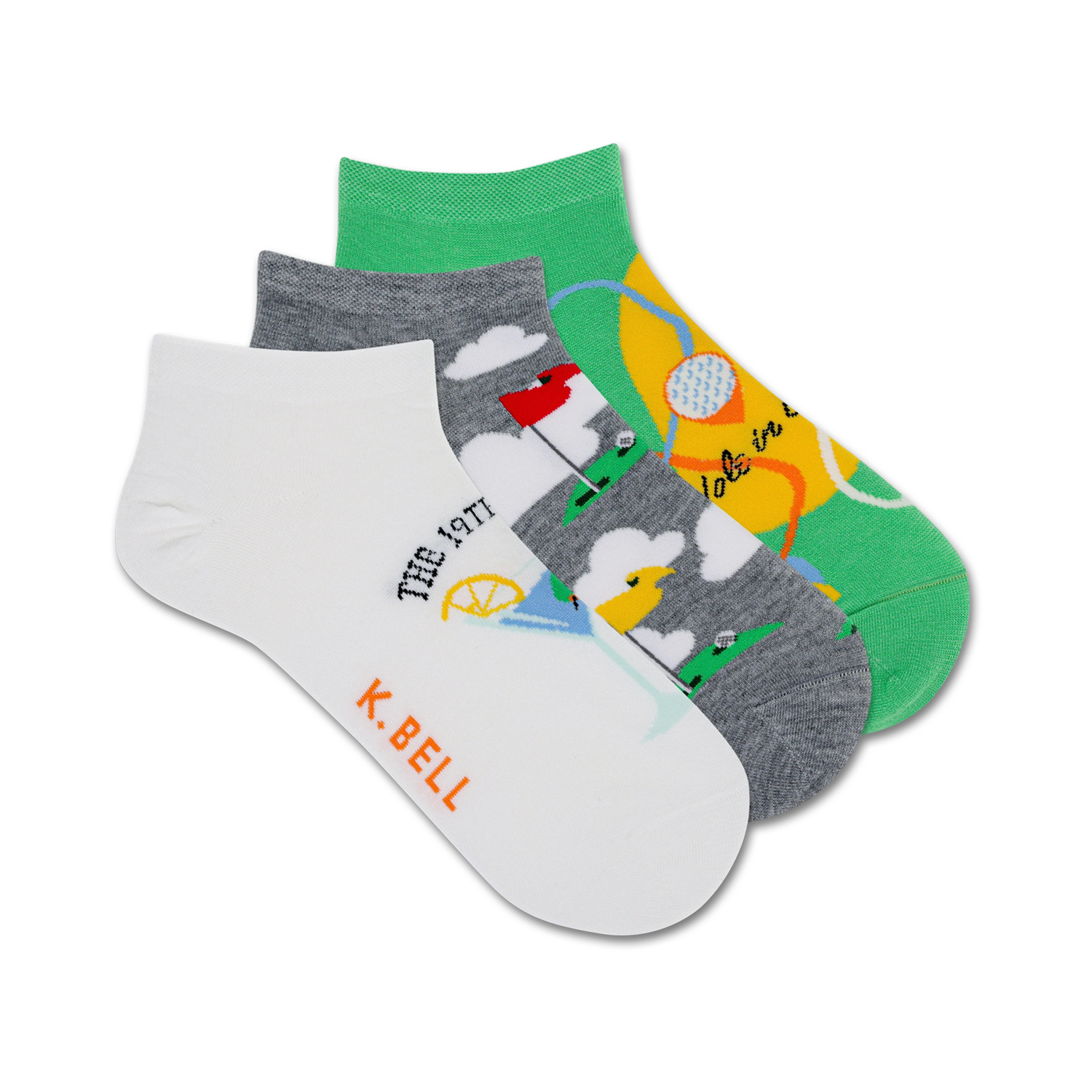 Three ankle socks; one white with golf-themed illustration, one gray with golf course, one green with golf ball. K. Bell logo.