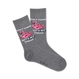 gray crew socks with pink flamingo design wearing sunglasses and floating on inner tube. text on socks reads "don't flock with me today."  