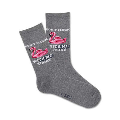 gray crew socks with pink flamingo design wearing sunglasses and floating on inner tube. text on socks reads "don't flock with me today."  