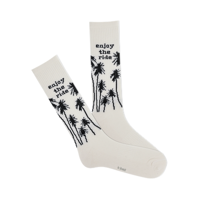 front view of white socks with black palm trees and "enjoy the ride" text.