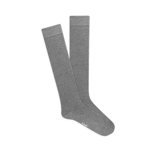 Pair of knee-high light grey Modal socks with subtle ribbed comfort tops, displayed flat on a black background.