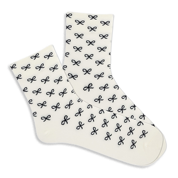 Pair of white microfiber anklet socks covered in a repeating pattern of small black bows, shown against a plain background.