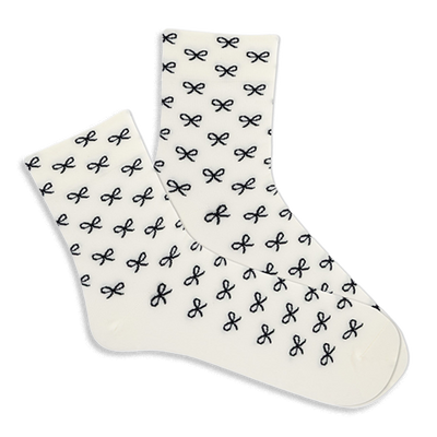 Pair of white microfiber anklet socks covered in a repeating pattern of small black bows, shown against a plain background.