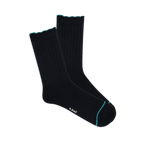 Pair of black ribbed wool blend crew socks with a teal scalloped cuff and a thin teal line on the toe, laid flat.